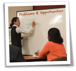 Instructor at white board writing "Problems and Opportunities"